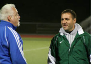 Steve Haggerty (left) jokes with KSS coach Troy Oeschlager before Tuesday’s game. Olympic won 1-0.