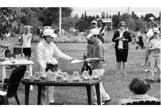 (above) Aubrey MacKenzie collecting his first place trophy Wednesday at the Fort Lewis Golf Course and (right) on the green.
