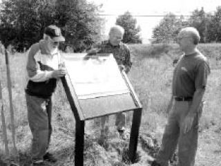 Volunteers install the first interpretive sign at Fish Park. Monthly work parties at the park start at 9 a.m. Sept. 20.