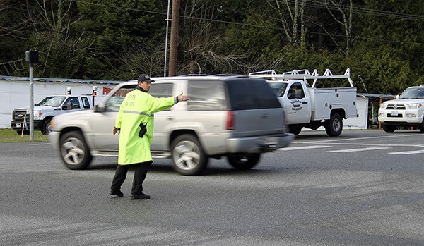 A Washington State Patrol trooper directs traffic in the intersection of Suquamish Way and Highway 305