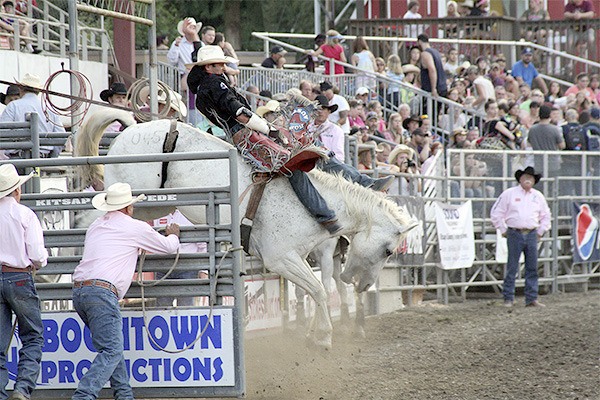 A rider and horse power out of the chute while onlookers cheer at the Kitsap County Rodeo & Stampede. This year’s events began Aug. 26 and continue through the weekend.