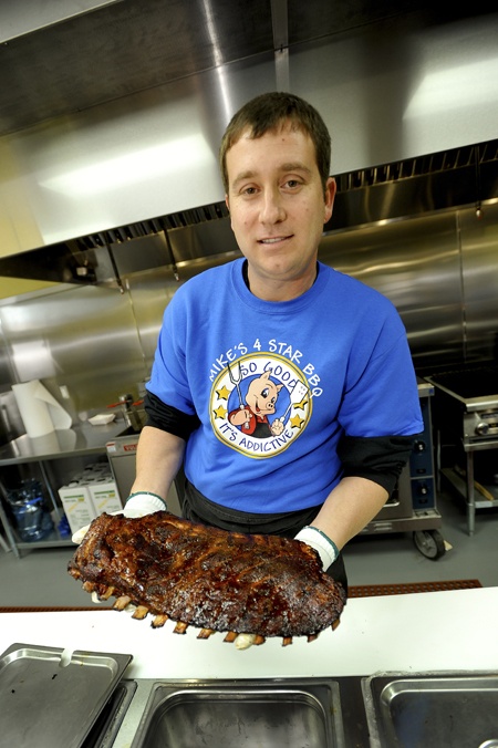 Mike Richman displays a slab of ribs at his new Carolina-style barbecue restaurant in Port Gamble.