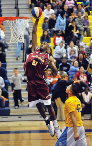 Harlem Ambassadors player Daytona Burch soars for a dunk during a fund-raising game in Texas. The Ambassadors will be in Bremerton Monday.