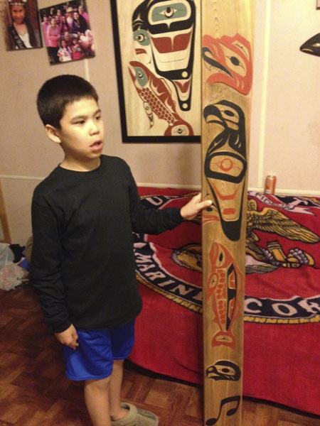 Manny Price holds the house post his dad made for the New Orleans Jazz & Heritage Festival