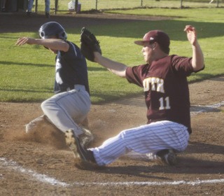 South Kitsap pitcher Scott McGallian is just a moment too late on the tag as  Carter Manning scores the first of Olympia’s 10 runs in the second inning via a wild pitch.