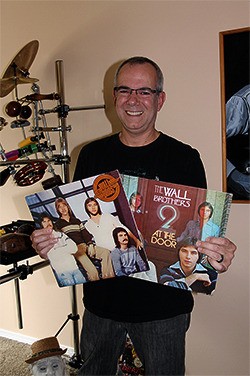 Bremerton resident Lance DeMers holds the albums from his days with the Wall Brothers. He now teaches private drum lessons.