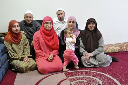 The Haji family poses for a portrait in their Bremerton home before laving for their near daily trip to their University Place Mosque for an evening of prayer and breaking of the daily Ramadan fasting.