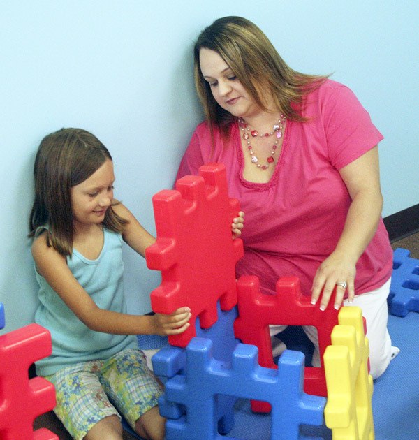 Co-owner Carrie Kaptur works with 8-year-old Abbigayle Hicks at Imagination Station Enrichment Center in the High Pointe Shopping Center on Bethel Avenue.