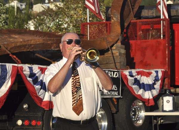 Jack Winegar plays “Taps” while standing in front of two steel beams recovered from the World Trade Center wreckage following the 9/11 attacks in New York. The beams are destined to become the centerpiece of the Kitsap 9/11 Memorial .