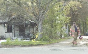 A South Kitsap Fire and Rescue firefighter walks away from a house on Sidney Avenue where a 47-year-old Port Orchard woman died early Wednesday morning.