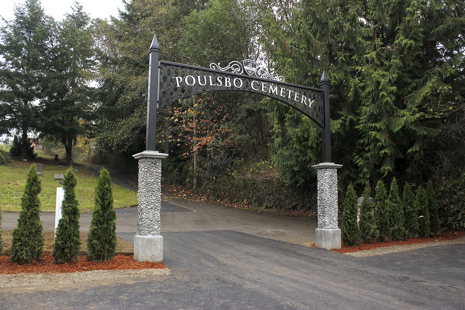 The completed entrance to the Poulsbo Cemetery on Caldart Avenue features a new wrought-iron sign and trees donated by the Historic Downtown Poulsbo Association.Sophie Bonomi / Kitsap News Group