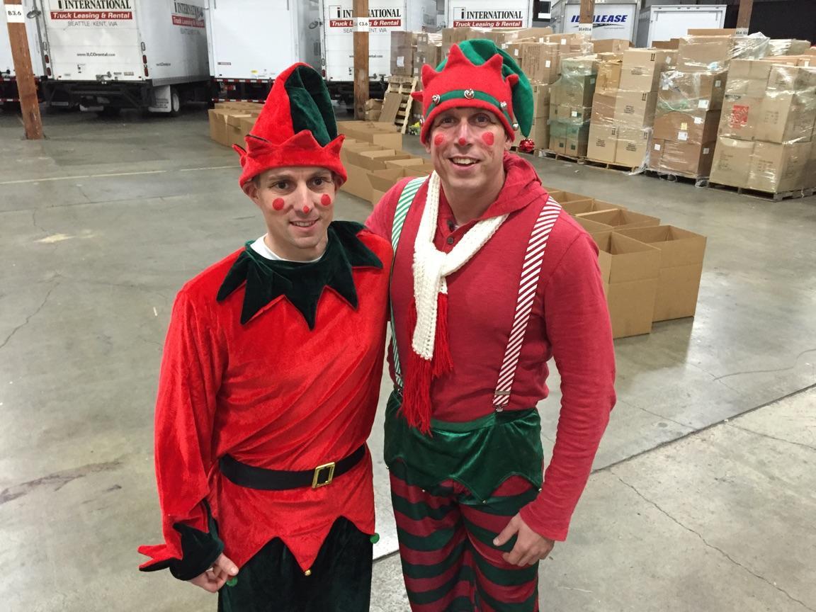 Brett Clark, right, manager of Poulsbo Les Schwab, dressed as an elf to deliver Christmas gifts on Christmas Eve 2015. With him is Seth Worley, manager of a Les Schwab in King County. (Contributed photo)
