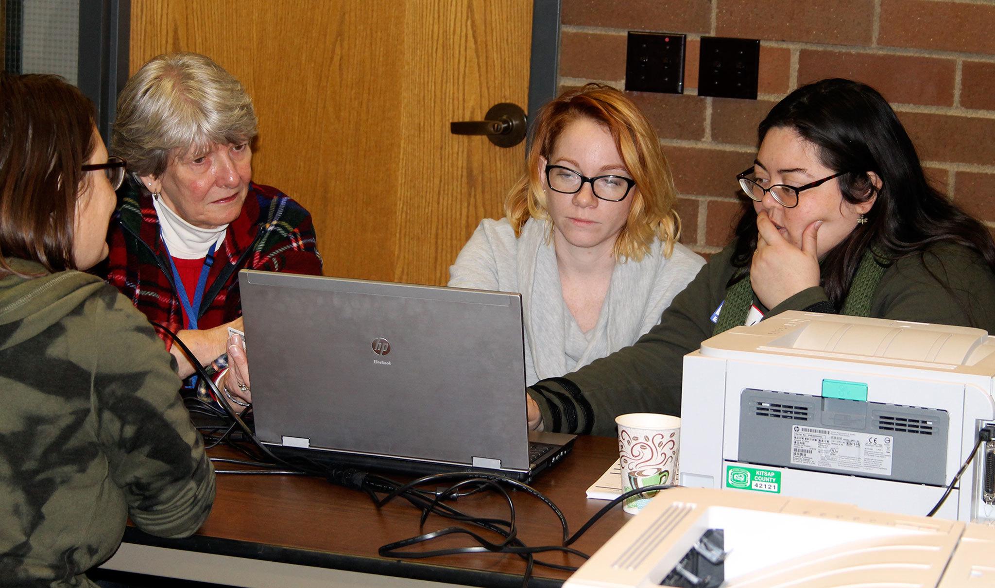 From left, Julia Stark, Josie Baxter and Hazel Simpson check a voter’s registration so the correct ballot can be given to her, Nov. 8 at the Poulsbo Fire Department polling station. In addition to ballot drop boxes throughout the county, the county staffs a polling place in Poulsbo and in Port Orchard. (Richard Walker/Kitsap News Group)