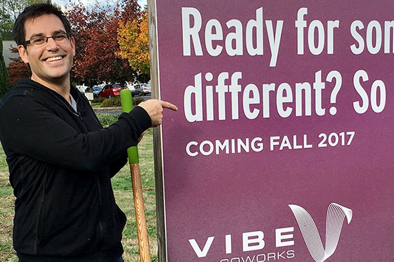 Marcel Imbach, cofounder of Vibe Coworks, posts a sign announcing the project’s upcoming construction. (Contributed photo)