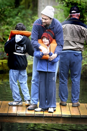 Ed Duarte helps his son Sean hook the first Trout to be caught Saturday during a Scoout Troop 544 outing from Silverdale at Webster's Pond in Poulsbo. The Kids Fish-In had about a dozen participants.