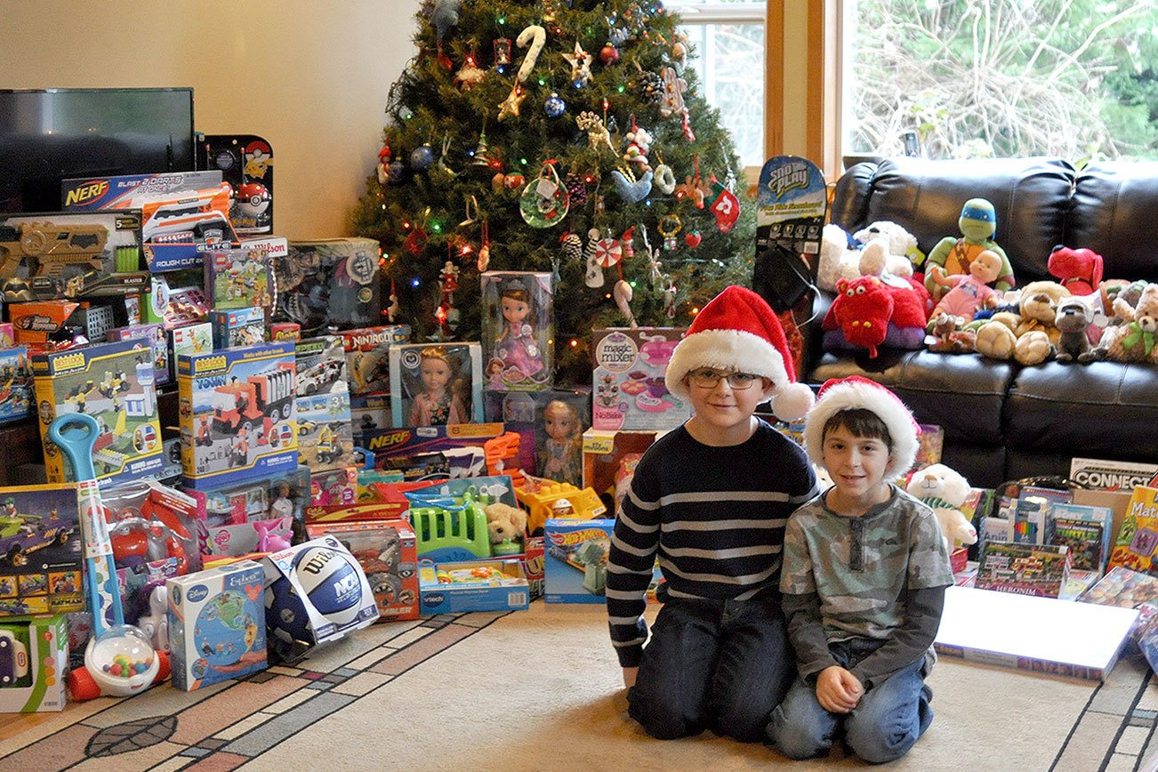 Ryan Downey, left, and Zachary Darner, right, sit surrounded by may of the toys they collected for their Kids Helping Kids toy drive.                                Michelle Beahm / Kitsap News Group