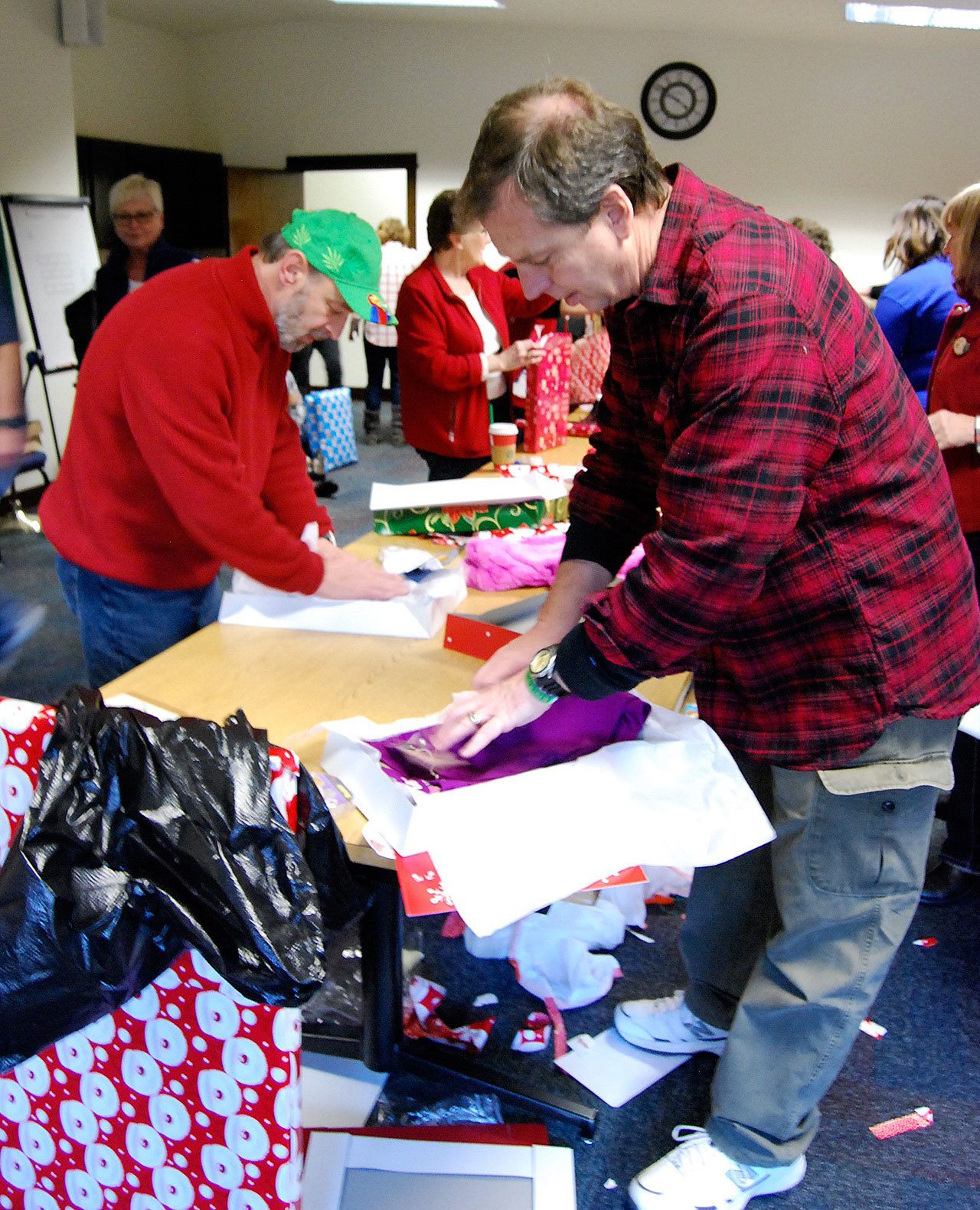 Volunteers Wayne Cohen (left) and Sean Smith wrap presents for a lucky child as part of the “Port Orchard Cares” event Saturday, Dec. 17. Bob Smith | Kitsap Daily News photo