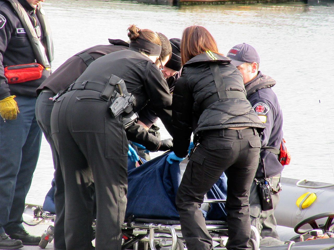 Emergency personnel prepare a person’s body for transport, Dec. 8 at Brownsville Marina. (Terryl Asla/Kitsap News Group)