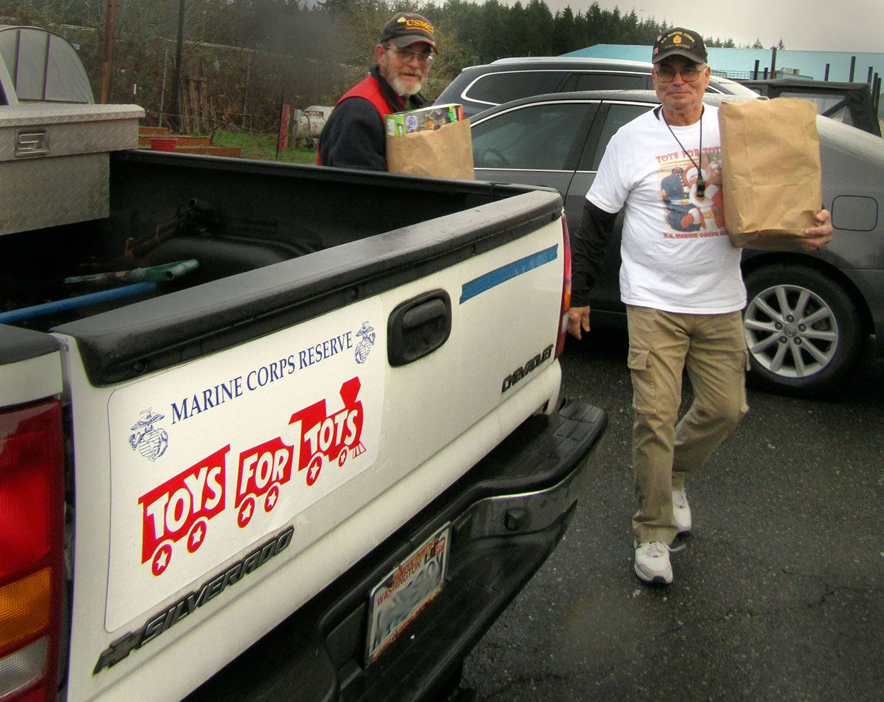 Gunny helps unload another pick-up load of toys. Terryl Asla/Kitsap Daily News
