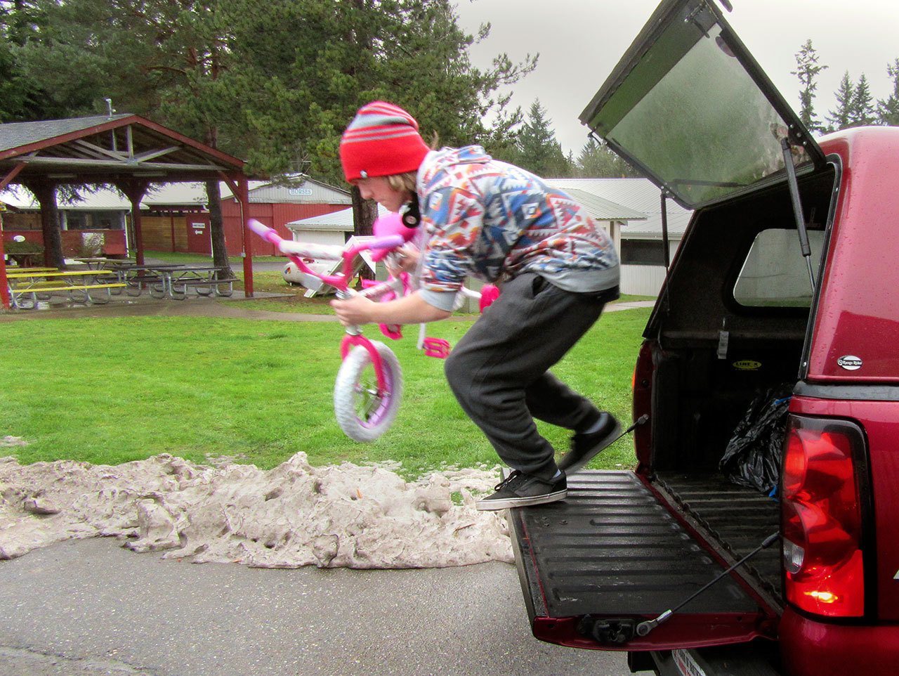 “One pink bike!” Volunteer unloads one of four brand-new bicycles that were donated by a family. Terryl Asla/Kitsap Daily News