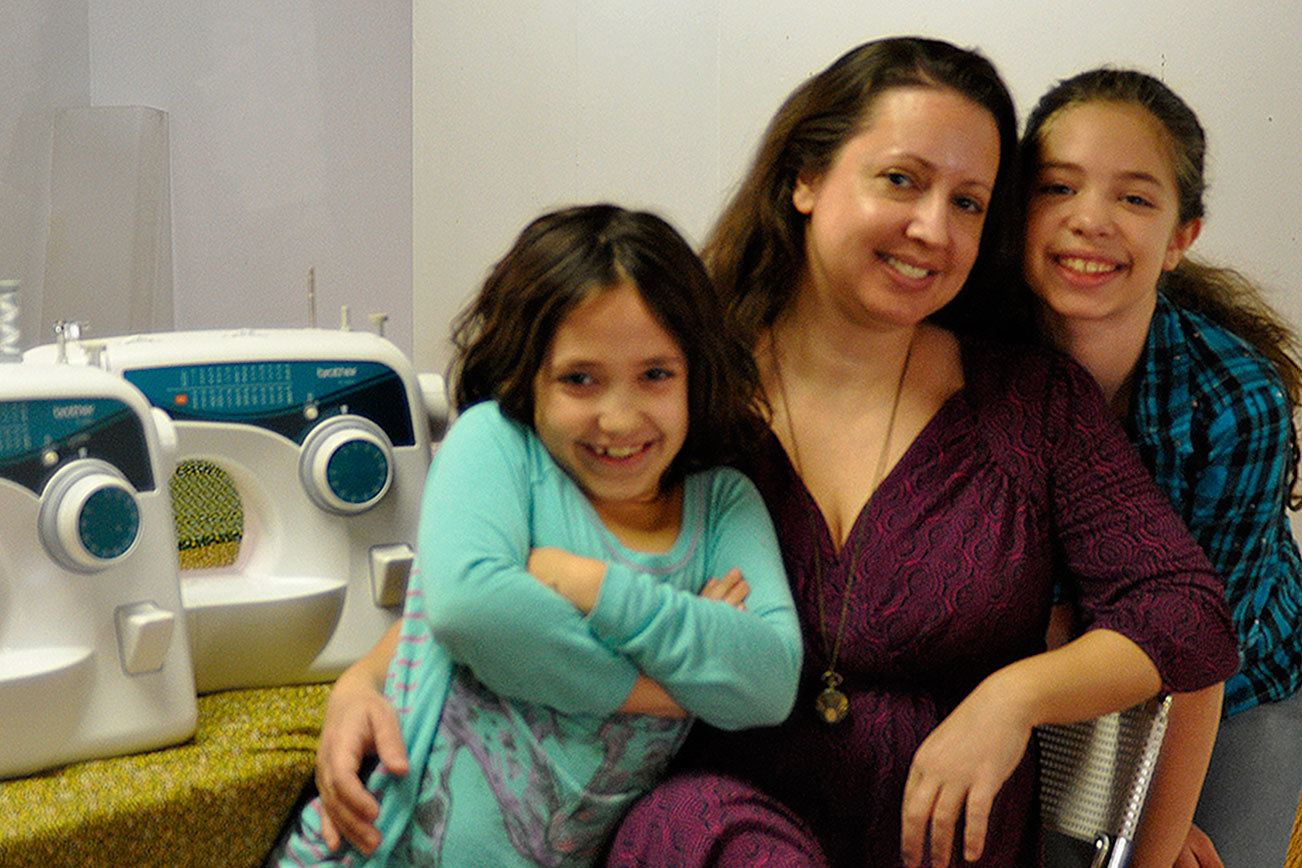 Melissa Dylan, center, and her daughters Eva, left, and Ruby, right, spend time at Dylan Fabrics. Melissa Dylan is hosting a suffragette flag sewing event at her store Dylan Fabrics.                                Michelle Beahm / Kitsap News Group