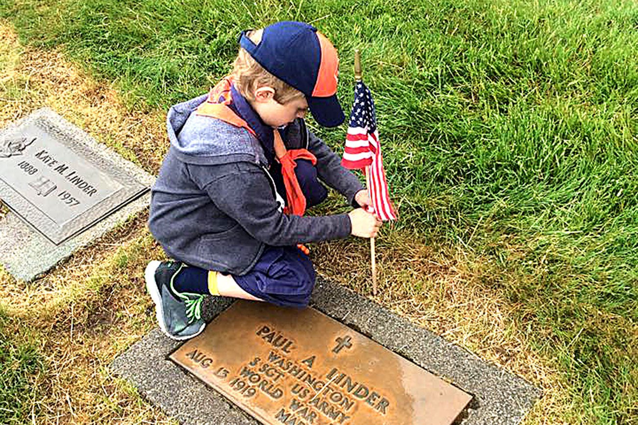 Tiger Cub Tristan Crittenden of Den 1, Pack 5239 chartered to VFW Post 239, places a flag upon the grave of Staff Sergeant Paul A. Linder, US Army, World War II at Miller-Woodlawn Cemetery on May 23, 2015, in honor of Memorial Day. Photo courtesy Keith Ciancio