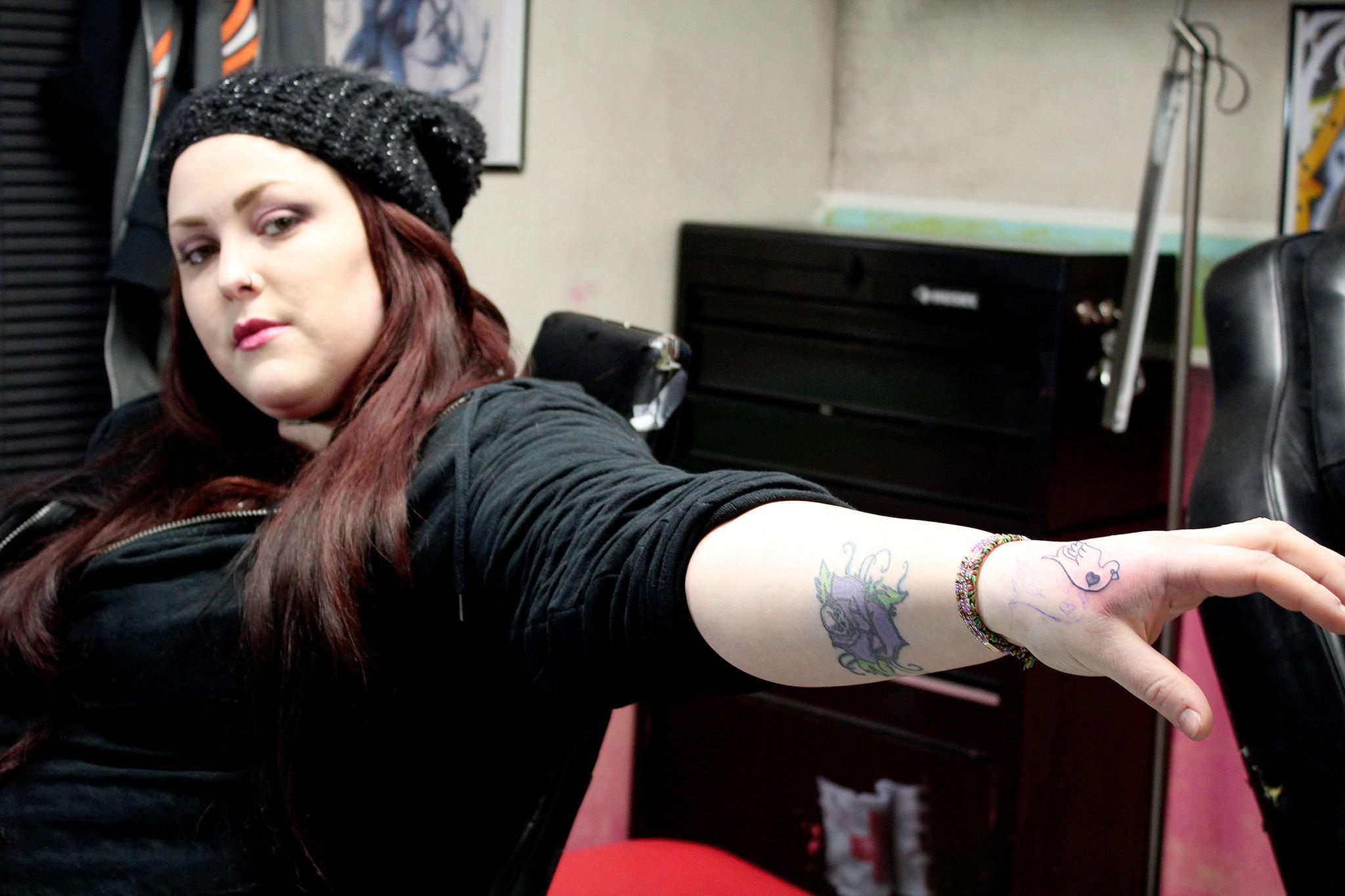 Amber Coe shows off her new turtledove tattoo, by Eric Flint, at The Clinic Tattoo.Michelle Beahm / Kitsap News Group
