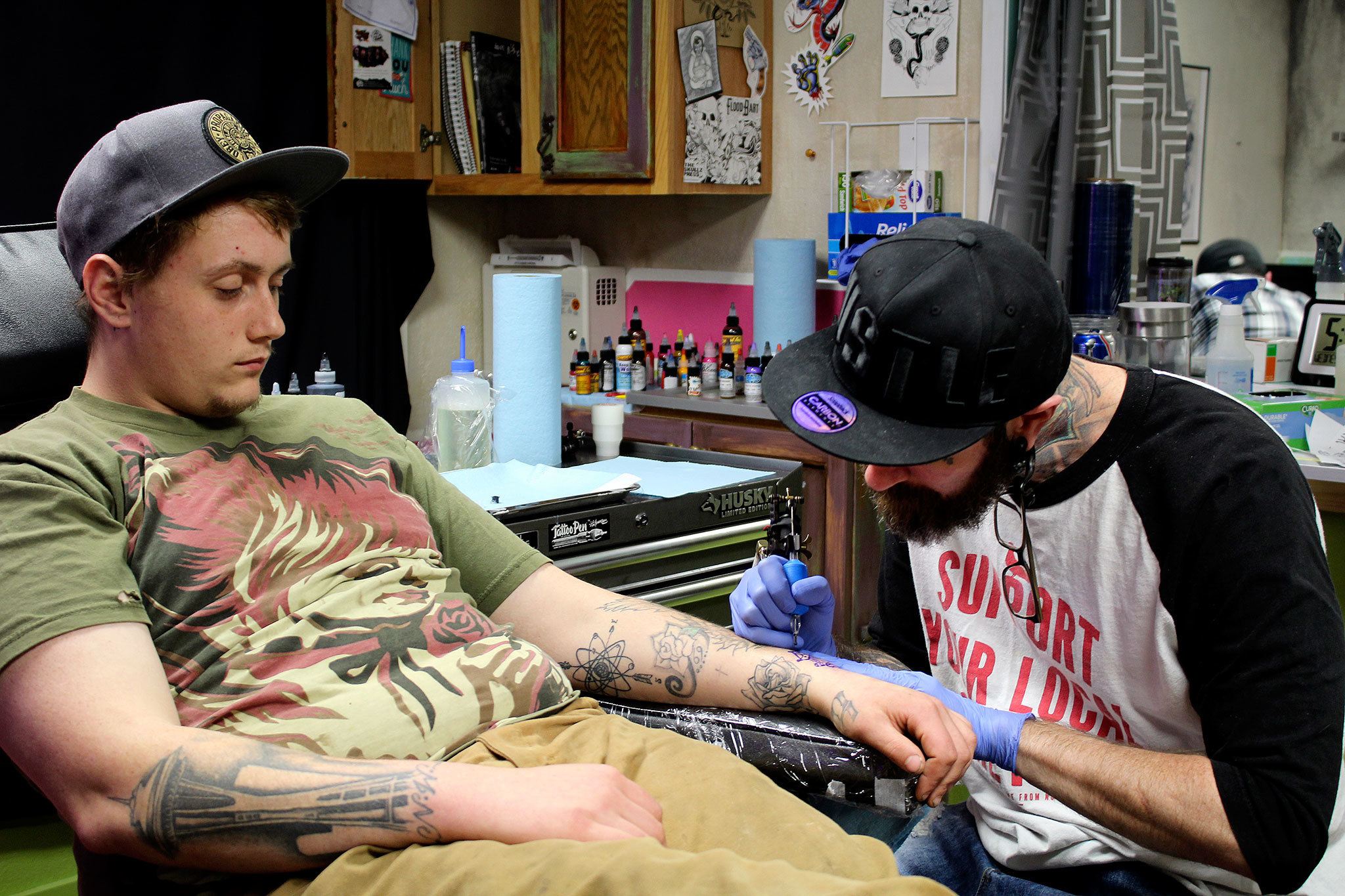 Paul Weaver starts work on Luke Bendorf’s tattoo on Valentine’s Day at The Clinic Tattoo.                                Michelle Beahm / Kitsap News Group