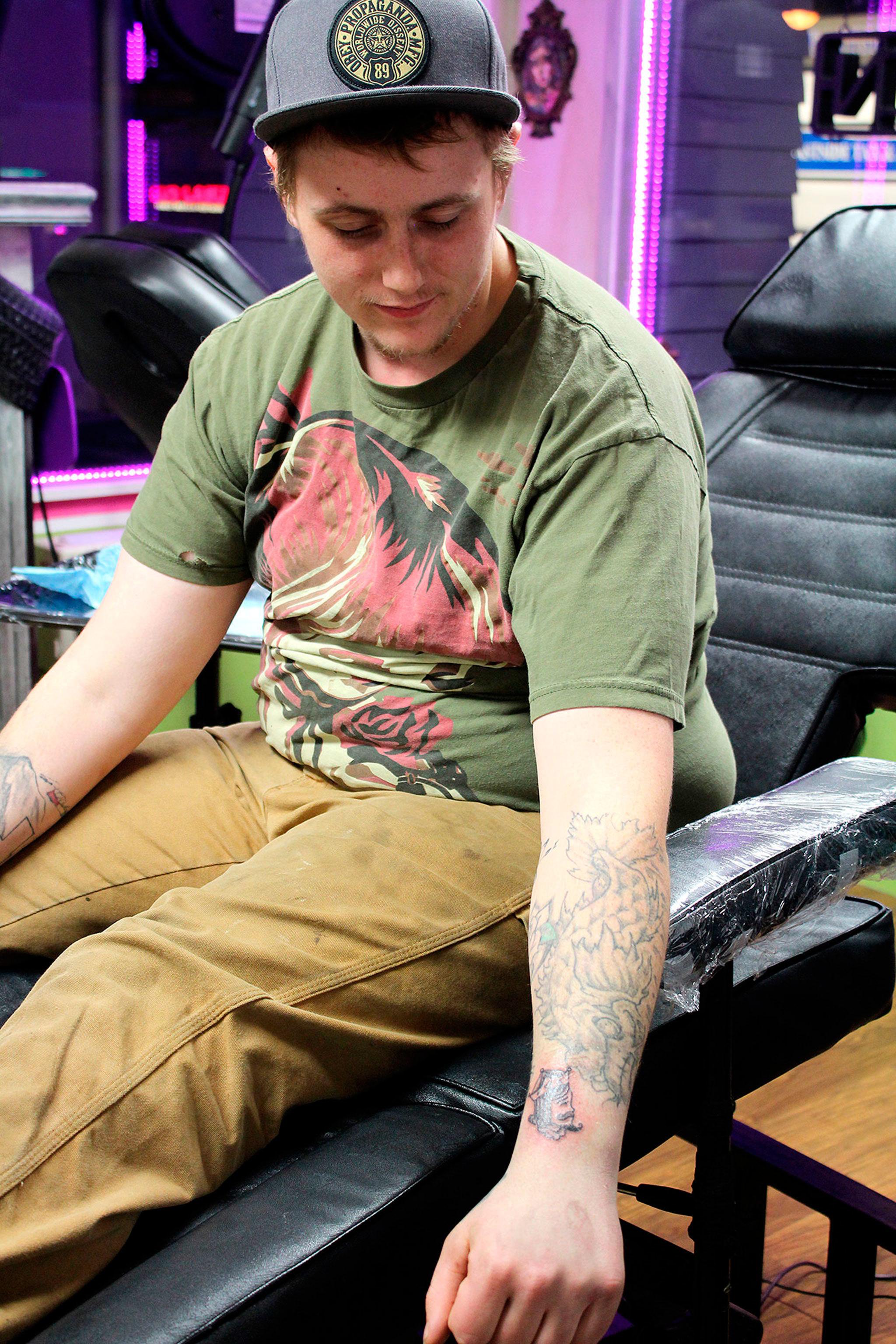 Luke Bendorf shows off his new flash tattoo, by Paul Weaver, on Valentine’s Day at The Clinic Tattoo.                                Michelle Beahm / Kitsap News Group