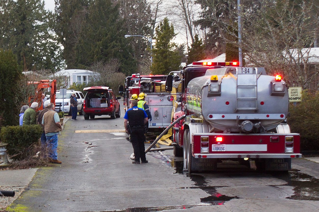 Cedar Glen residents watch as firefighters respond to a fire at the mobile home park Feb. 21. Sophie Bonomi / Kitsap News Group