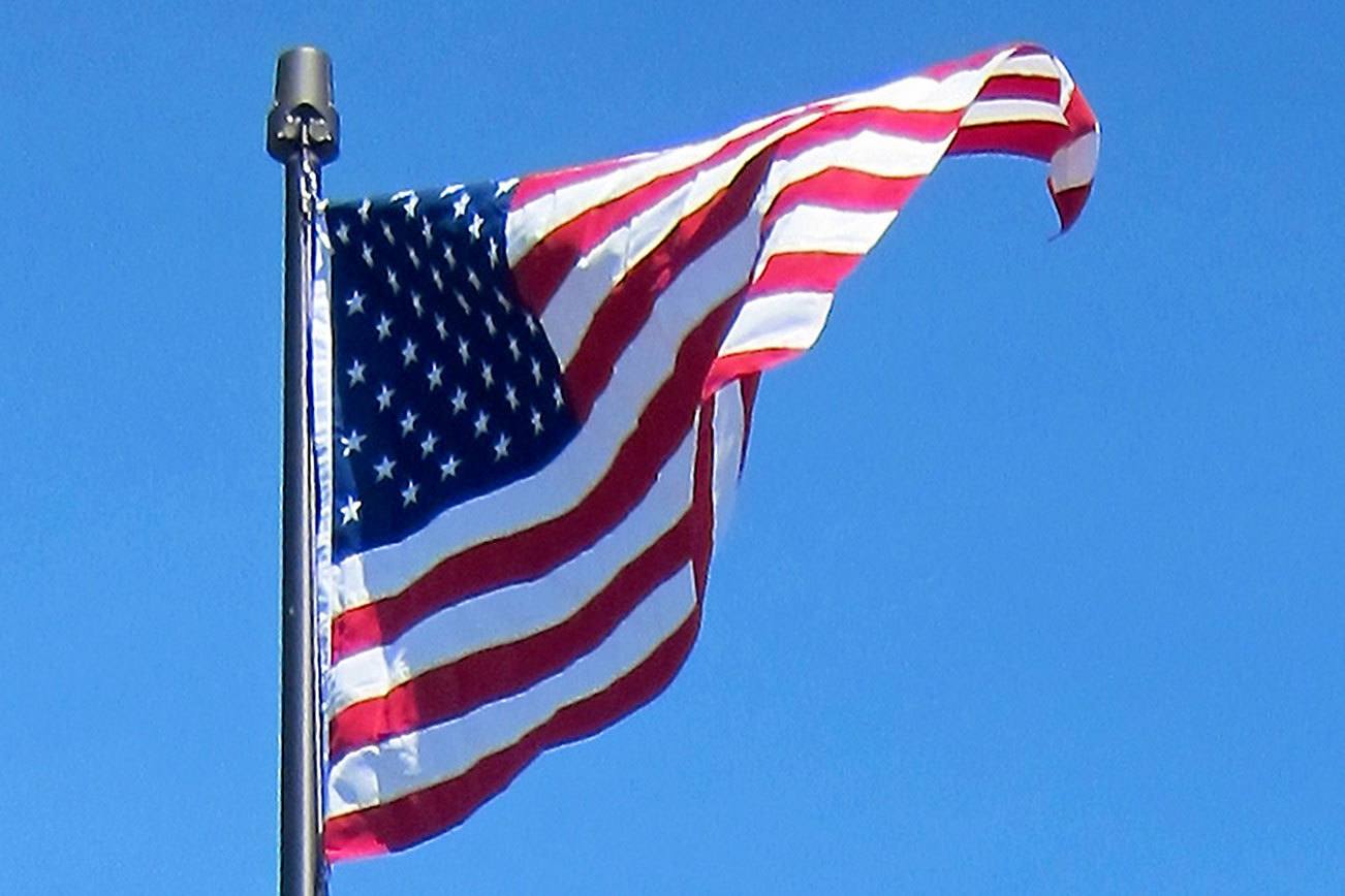 The American flag waves outside of Kingston’s Village Green Community Center on a sunny day. (Judith Ryan / Contributed)