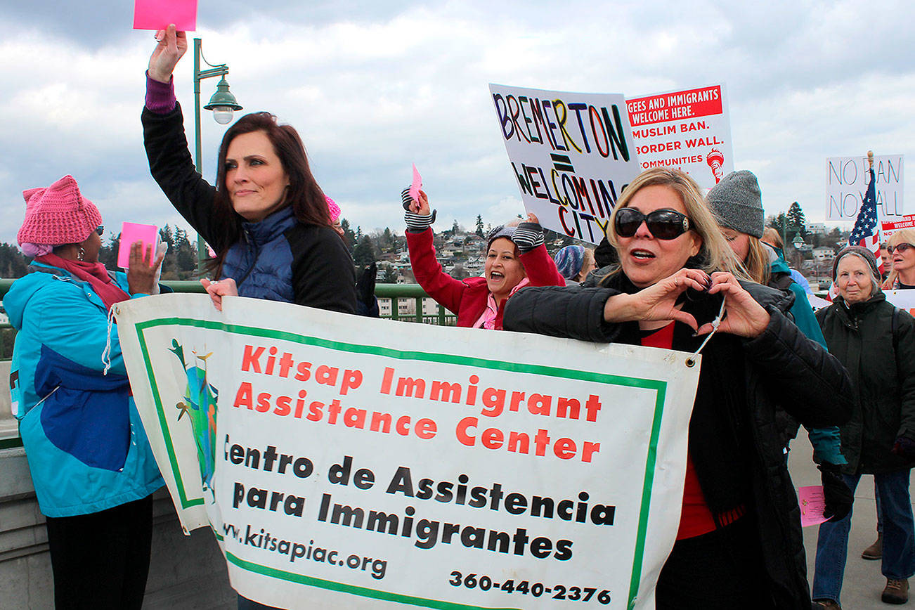 Representatives of the Kitsap Immigrant Assistance Center at the Kitsap Builds Bridges, Not Walls vigil Feb. 25. KIAC is an important resource for the local immigrant community.                                Michelle Beahm / Kitsap News Group