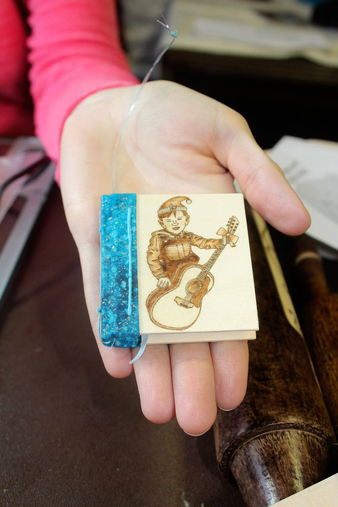 Here’s an example of one of April Shelton’s tiny, handmade books. She decorates the wooden covers and gives them away to children in memory of her late father. She learned book making at the Port Orchard Library.                                Terryl Asla / Kitsap News Group