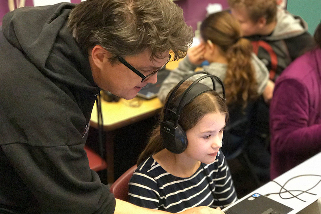 Wolfle Elementary music teacher Michael McCurdy assists a fifth-grade student with their music software program Feb. 15. (Jenn Markaryan / Contributed)