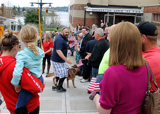 Air Force TSgt. Daniel Fye and his service dog, Susie, were surrounded by well-wishers after Fye and his family arrived in a motorcade. (Terryl Asla/ Kitsap News Group)