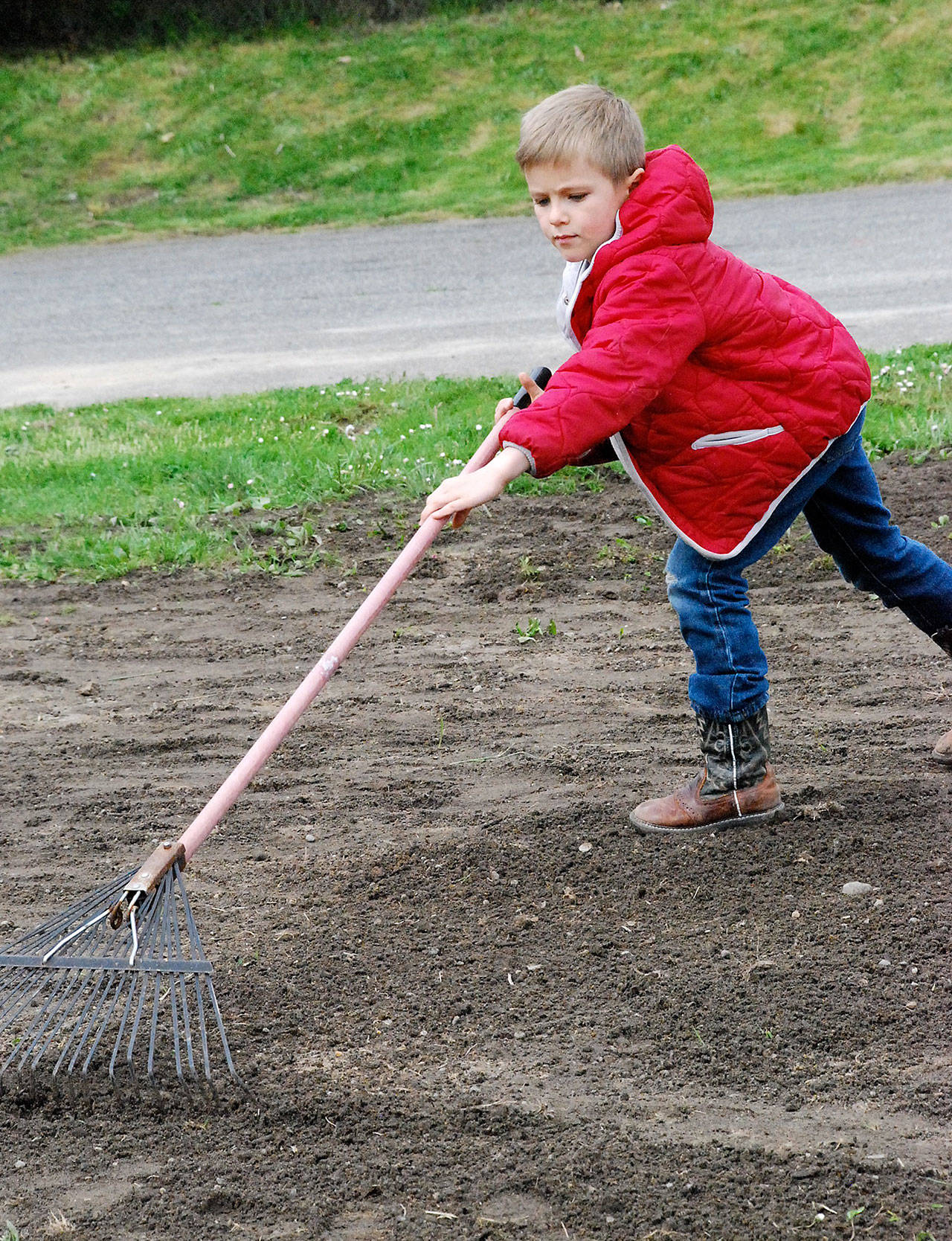 Benney Hyde, 7, rakes in filler topsoil on the playfield at Central Park during Port Orchard Community Service Day April 29.