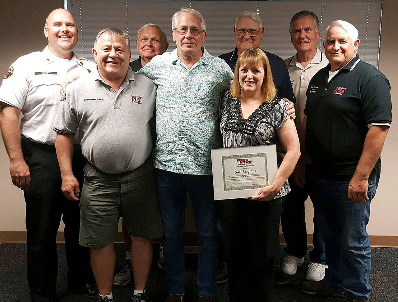 Brian Smith (front row, center) is joined by Gail Bergland (to the right of Smith) and the South Kitsap Fire and Rescue Board of Commissioners, and Assistant Fire Chief Jeff Faucett (back row, left). Photo: South Kitsap Fire and Rescue