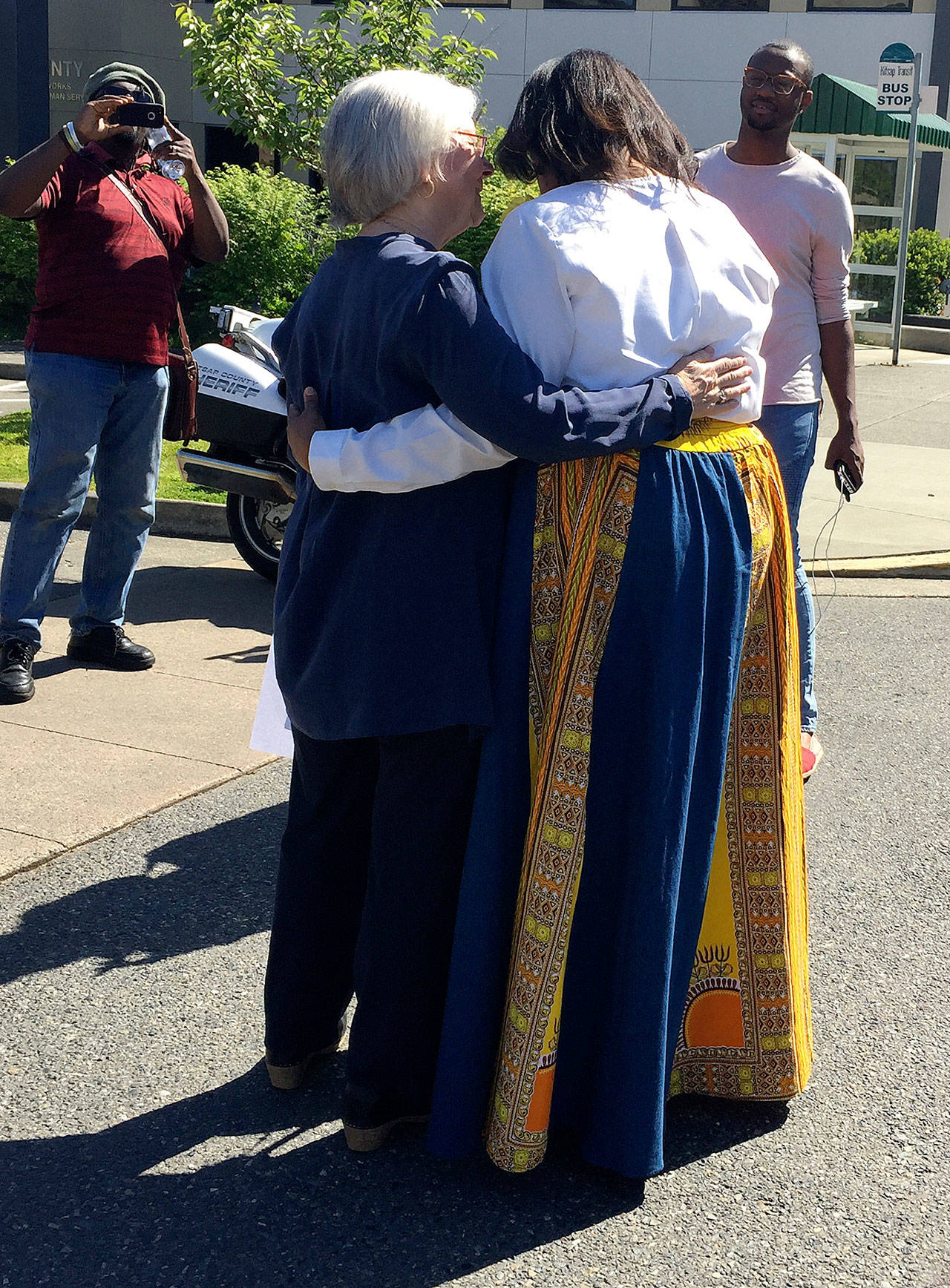 Following her rendition of “Amazing Grace,” Willie Mae Sharpe receives a hug from Charlotte Garrido, Kitsap County commissioner. Garrido gave welcoming remarks at the start of the event. Photo: Bob Smith | Kitsap Daily News
