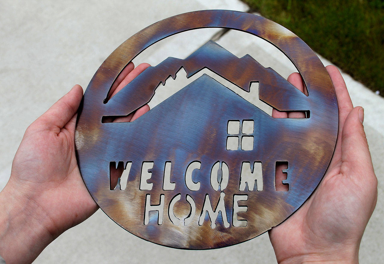 Besides the house keys, the nine new homeowners received burnished stainless steel “Welcome Home” plaques to hang by the front doors of their new residences. Asla/Kitsap News Group