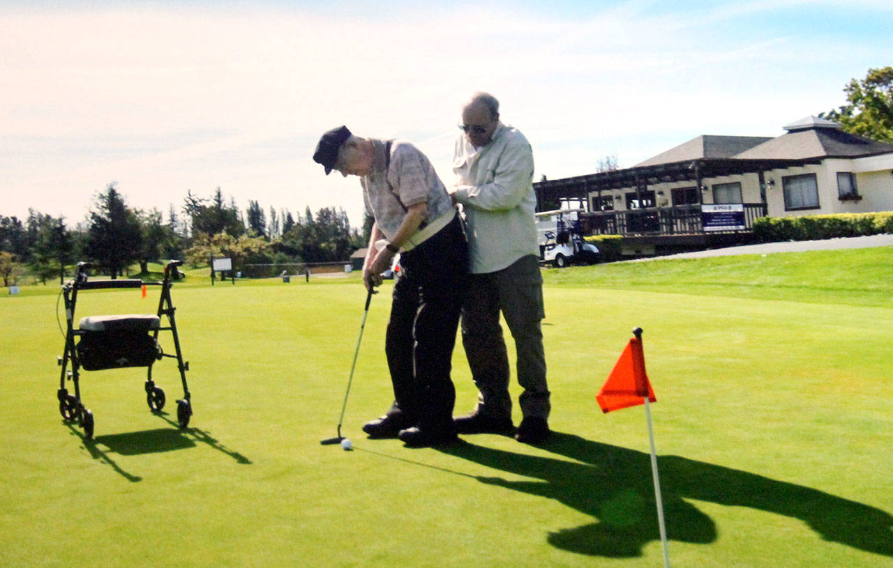 Dan Wenzlaff, his son, Bob, standing nearby, putts at a golf course in Napa, California, in November 2016. The elder Wenzlaff was 103. (Wenzlaff family photo)