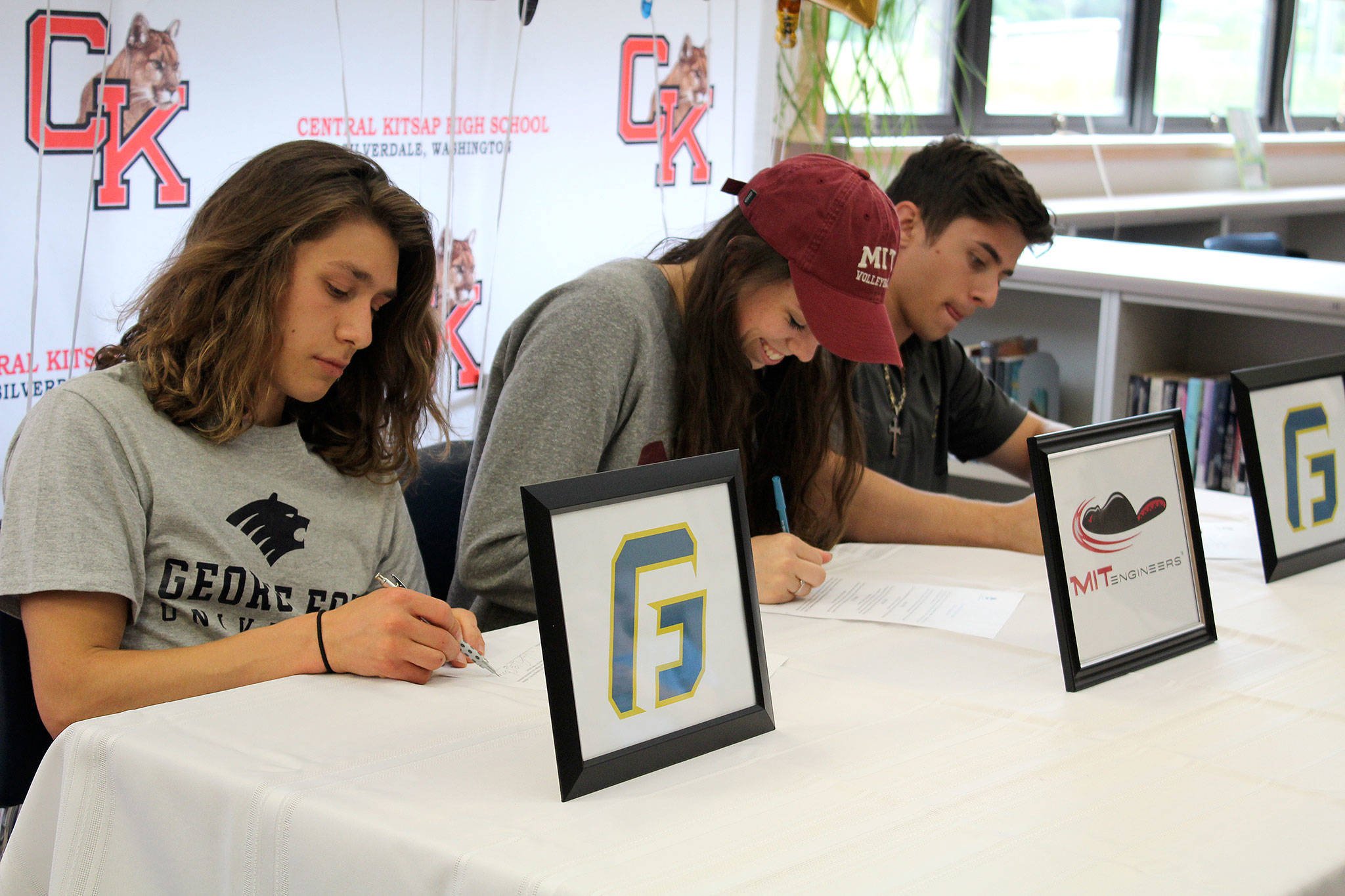 From left, Caleb Giesbrecht, Katelyn Downey and Cody Davis committed to universities May 31. Giesbrecht will be on the cross country team for George Fox University, Downey will be a volleyball player at MIT and Davis will be on the track and field team at George Fox University.                                Michelle Beahm / Kitsap News Group