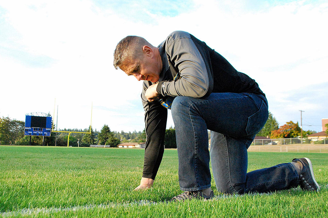 Joe Kennedy kneeling on the 50-yard line of a football field in prayer.                                Courtesy Liberty Institute