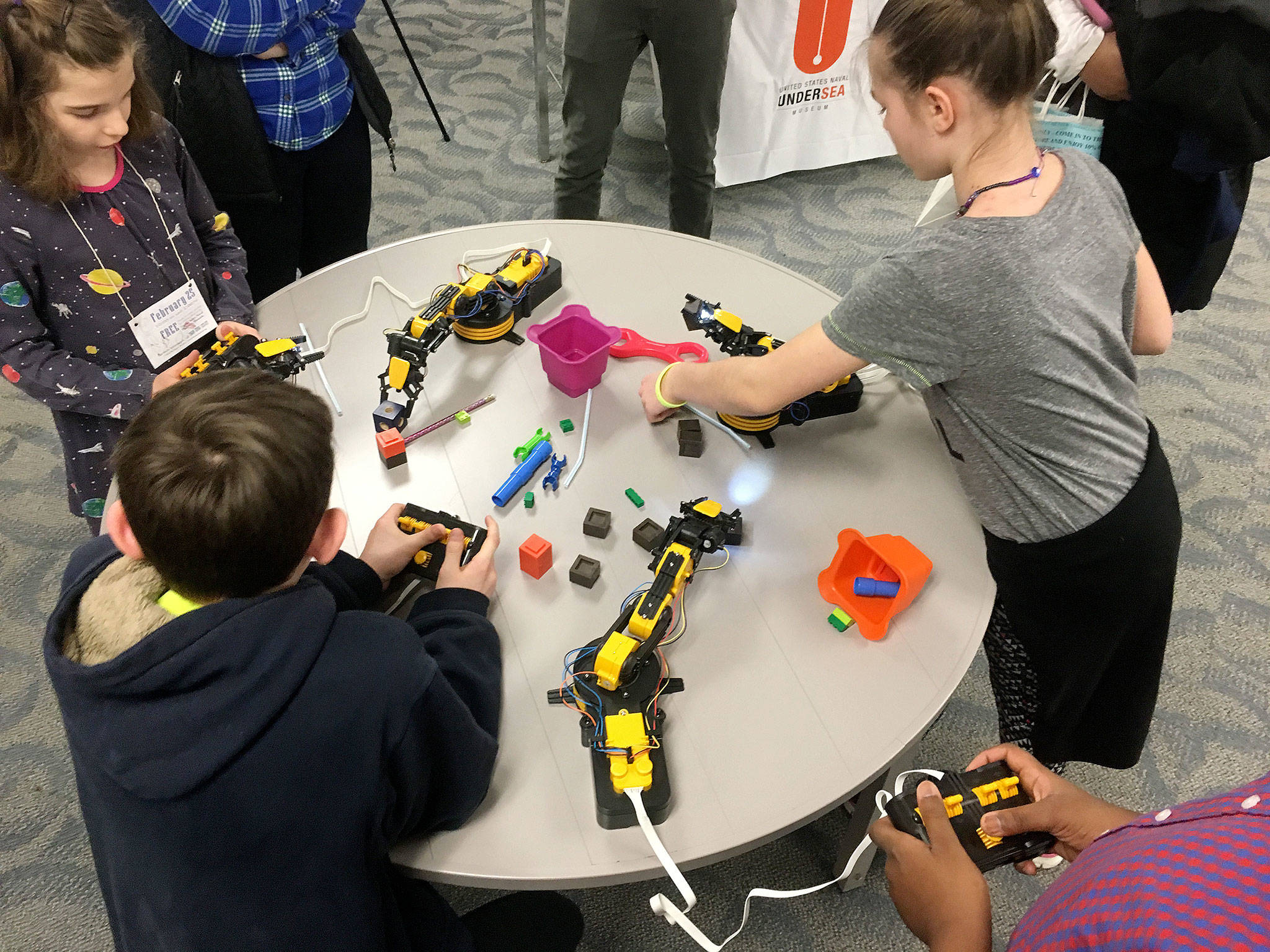 Children operate robotic arms at a 2016 Summer STEAM program.                                Photo courtesy of the U.S. Naval Undersea Museum