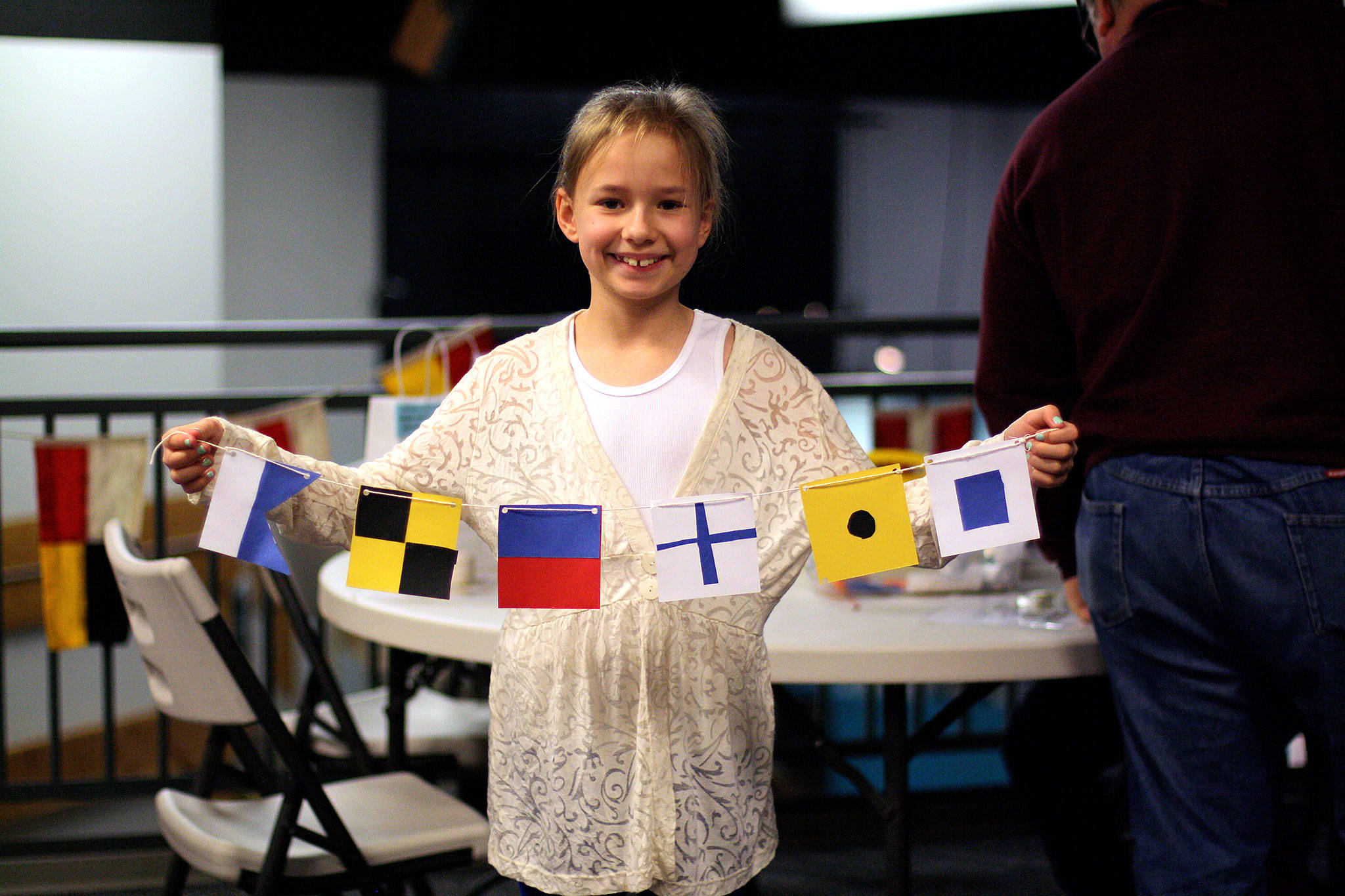 A child shows off a signal flag message made at 2016 Summer STEAM.                                Photo courtesy of the U.S. Naval Undersea Museum