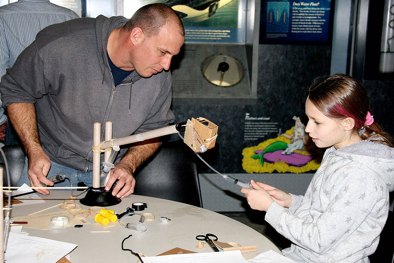 A child and caregiver create a hydraulic lift at Summer STEAM at the Naval Undersea Museum in 2016.                                Photo courtesy of the U.S. Naval Undersea Museum