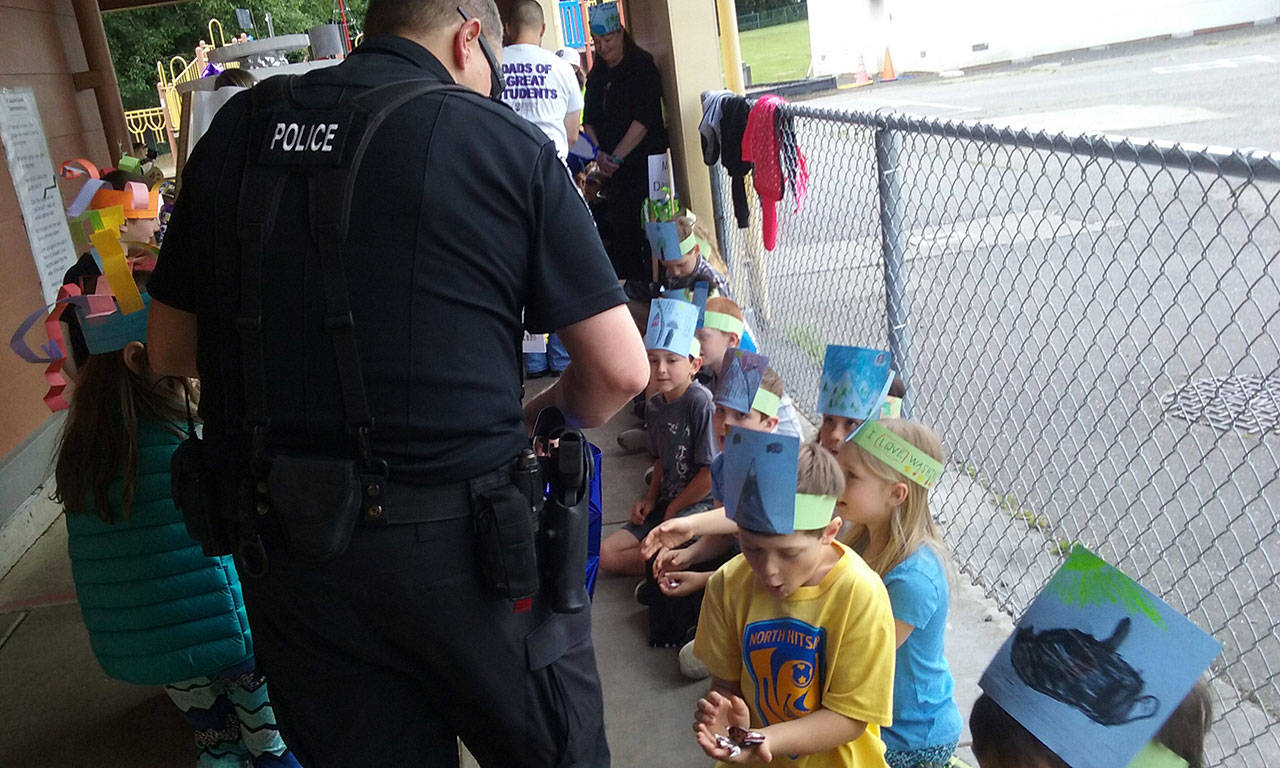 Poulsbo police hand out candy to students as they go by. (Ian A. Snively/Kitsap News Group)
