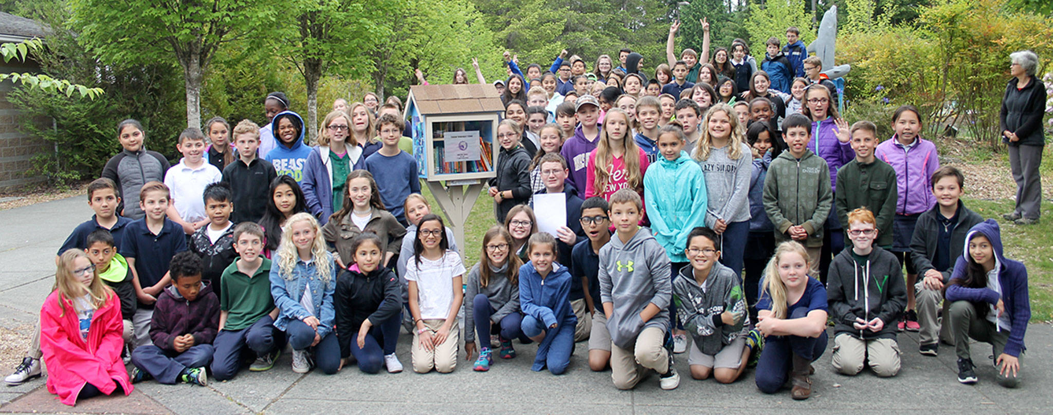 Fifth-graders at Vinland Elementary pose with their graduation gift to the school: a Little Free Library filled with donated books. Terryl Asla/Kitsap News Group