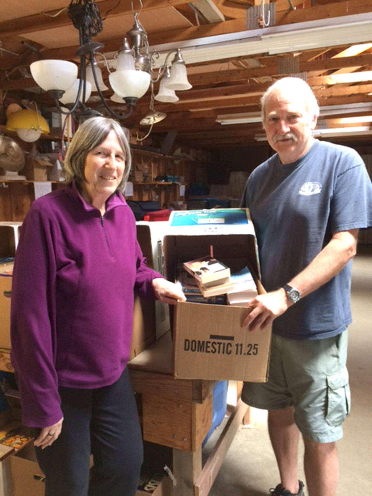 Alix Kosin and Howie O’Brien sort more than 5,000 books in preparation for the big Greater Hansville Community Center book sale June 9-11. (Annette Wright / Contributed)