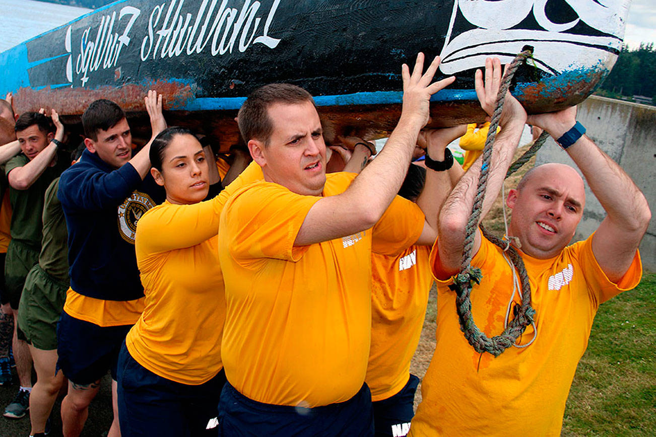 Sailors from Naval Base Kitsap carry a canoe to the lawn outside the House of Awakened Culture, July 20, during the 2017 Canoe Journey. Canoe families are traveling to We Wei Kai and Wei Wai Kum First Nations territory at Campbell River, B.C. Suquamish was an early stop for Puget Sound indigenous nations traveling in the annual gathering of Northwest canoe cultures. (Richard Walker/Kitsap News Group)