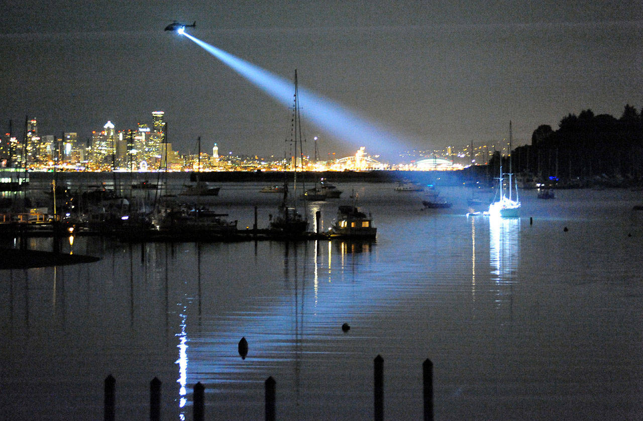 King County Sheriff’s Department Guardian One helicopter shines a light on the sailboat Flying Gull after a gunman aboard the vessel began shooting at the shoreline along Eagle Harbor on July 8. (Diane Satterwhite photo)